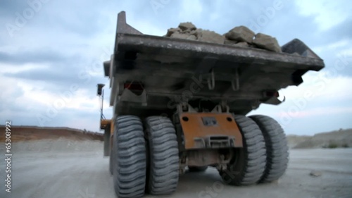 Heavy mining dump truck being loaded with iron ore