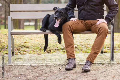 Best friends: Young man sitting with his dog on a bench
