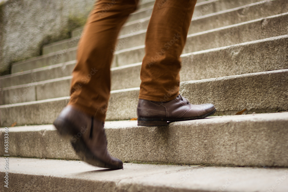 Walking upstairs: close-up view of man's leather shoes Walking upstairs: close-up view of man's leather shoes
