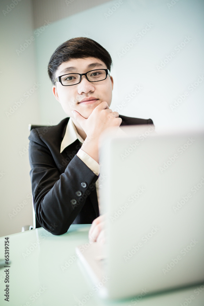 Young handsome man using laptop in his office Young handsome man using laptop in his office