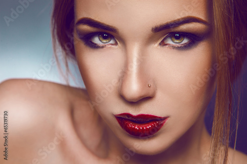 Horizontal photo of serious adult girl with nice make up in stud