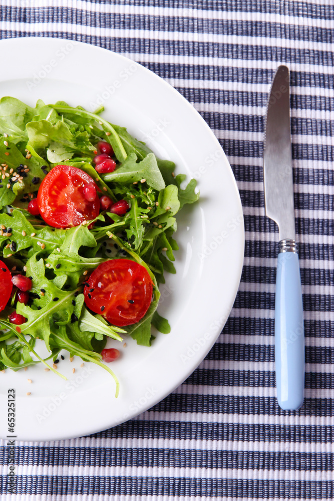 Green salad made with arugula, tomatoes and sesame Green salad made with arugula, tomatoes and sesame