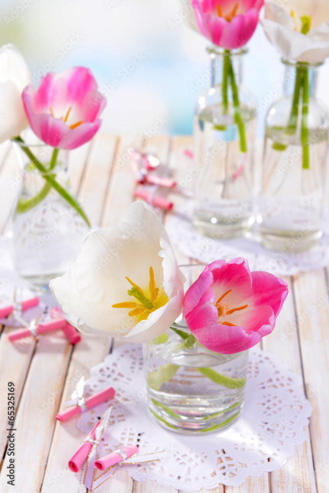 Beautiful tulips in bucket in vase on table on light background Beautiful tulips in bucket in vase on table on light background