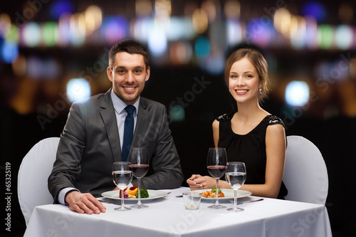 smiling couple eating main course at restaurant