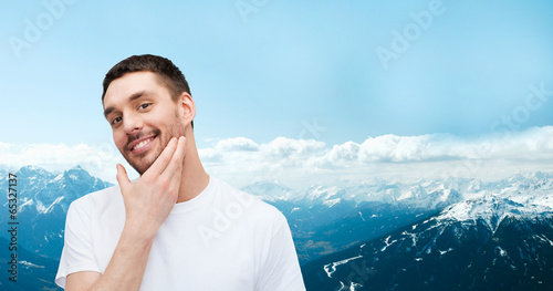 beautiful smiling man touching his face