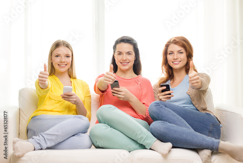 smiling teenage girls with smartphones at home © Syda Productions
