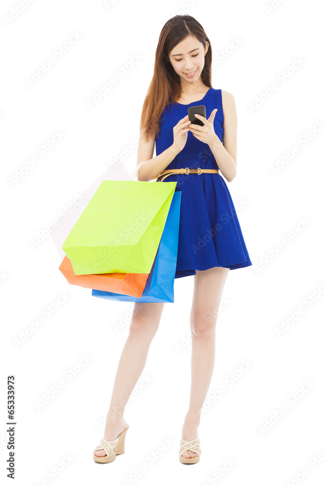 young  woman holding shopping bags and touching on the phone