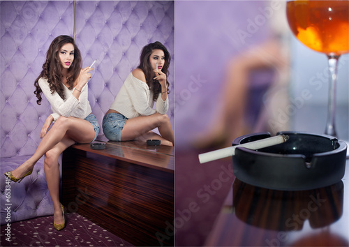 Obraz na płótnie Young sensual woman siting smoking in a modern night club w salonie