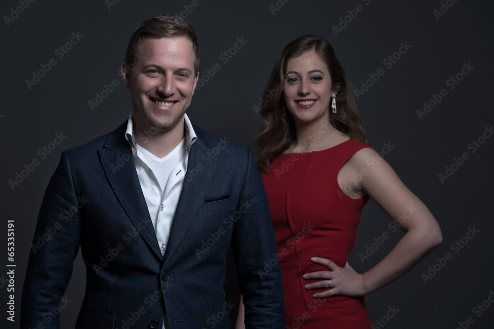 Fashion couple wearing a red dress and blue jacket. Young man an Fashion couple wearing a red dress and blue jacket. Young man an