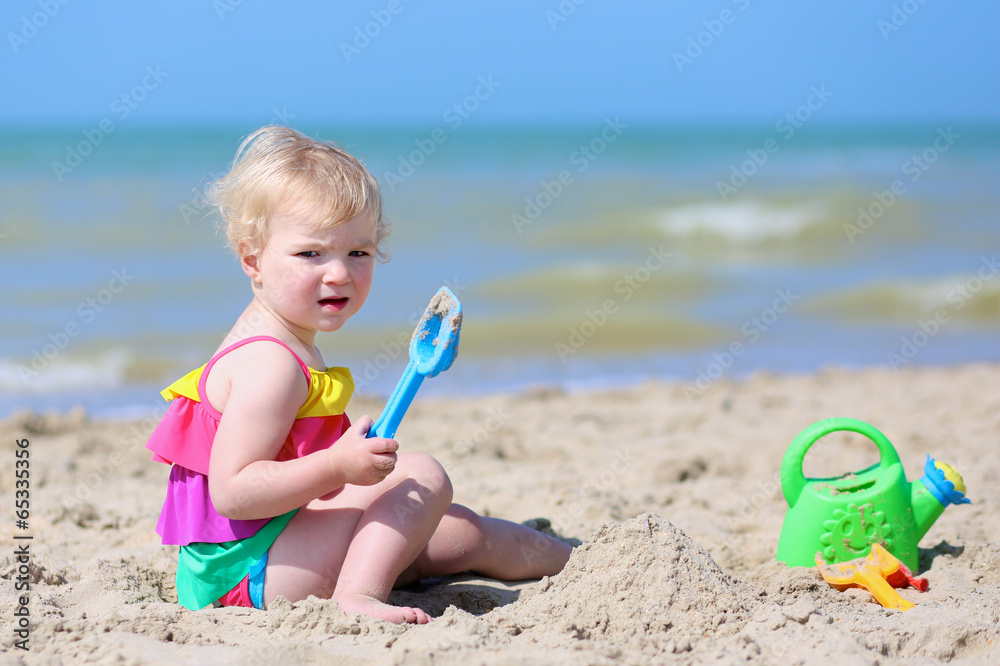 Cute little girl building sand castles on tropical beach Cute little girl building sand castles on tropical beach