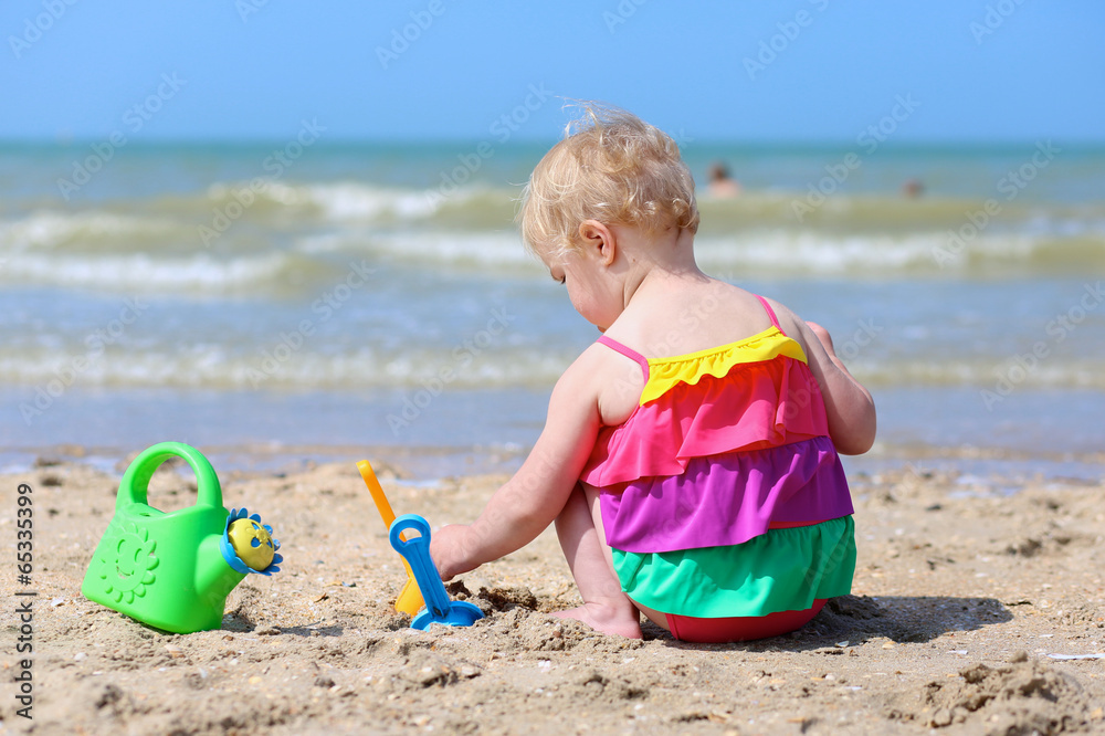 Cute little girl building sand castles on tropical beach Cute little girl building sand castles on tropical beach