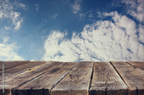 rustic wood board in front of sky with clouds 