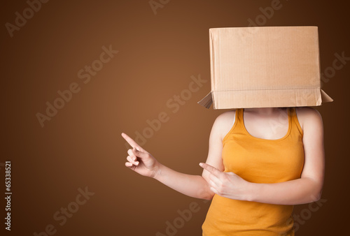 Young girl gesturing with a cardboard box on his head photo