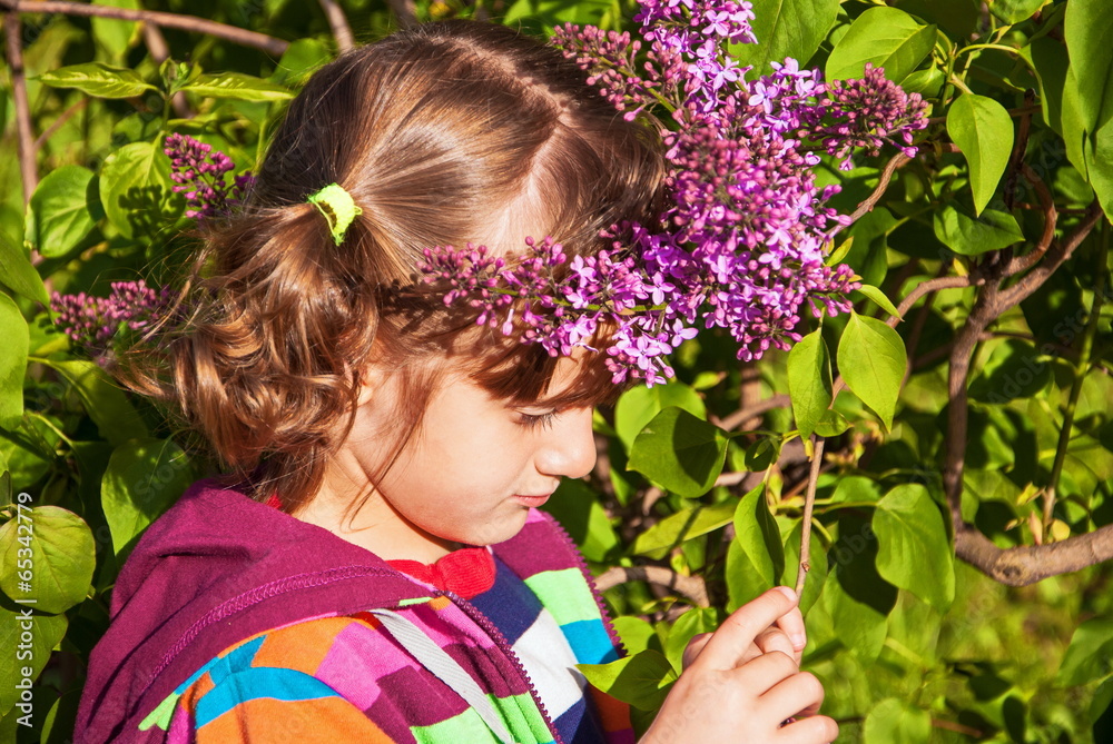 Little sad girl in the garden of lilac bushes Little sad girl in the garden of lilac bushes