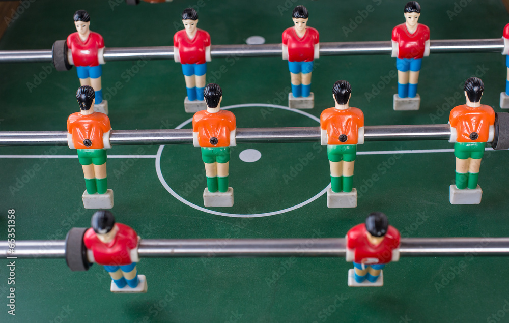 Table football game with red and orange players Table football game with red and orange players