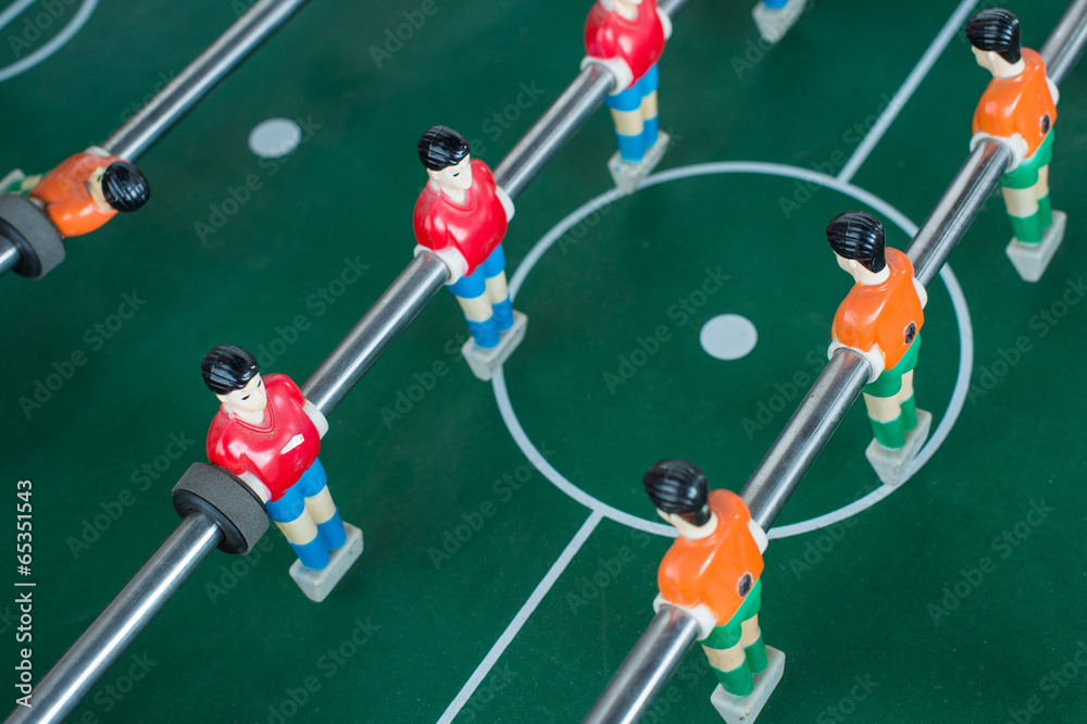Table football game with red and orange players Table football game with red and orange players