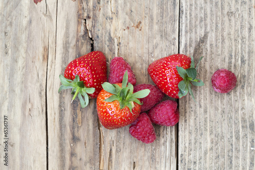 fresh local strawberries, raspberries shot on rustic wooden back photo