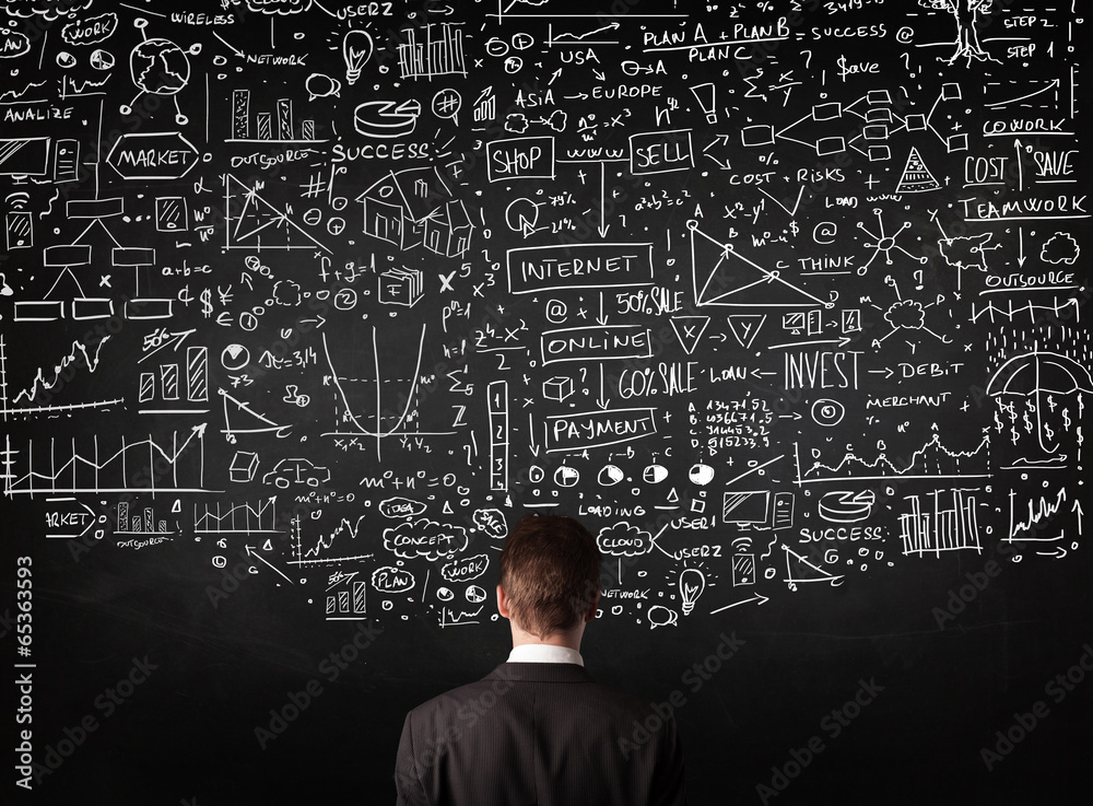 Businessman standing in front of drawn charts on a blackboard Businessman standing in front of drawn charts on a blackboard