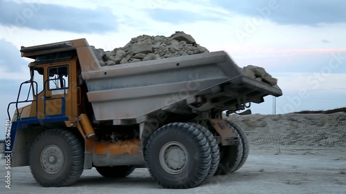 Heavy mining dump truck being loaded with iron ore