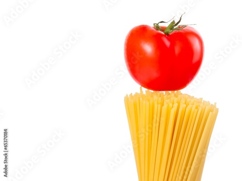 raw pasta spaghetti with tomato on top on white background