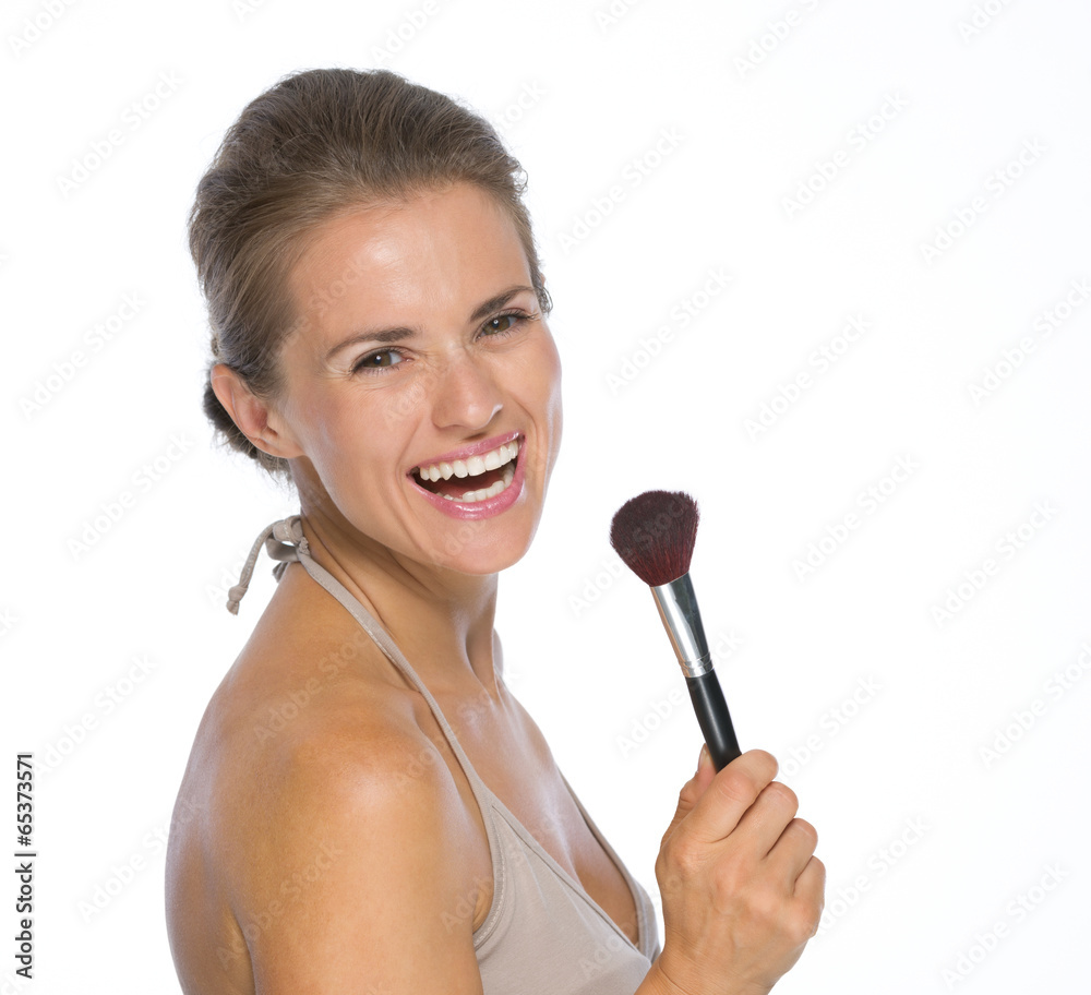 Portrait of smiling young woman with makeup brush Portrait of smiling young woman with makeup brush