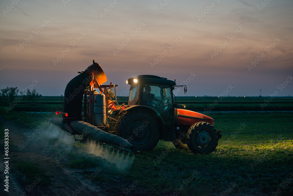 Naklejka premium tractor spraying pesticides