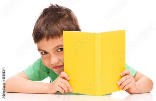 Little boy plays with book