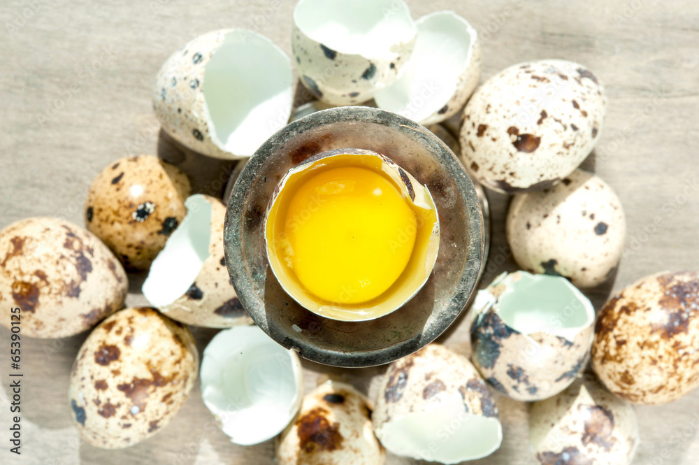 Quail egg yellow yolk top view. Eggshell. Indoors closeup. Quail egg yellow yolk top view. Eggshell. Indoors closeup.