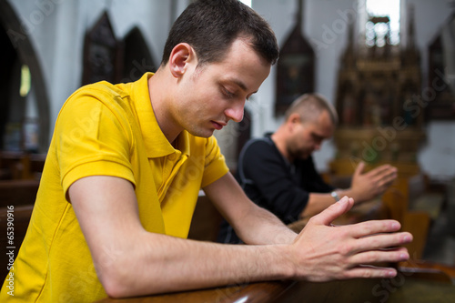 Photography Handsome young man praying in a church