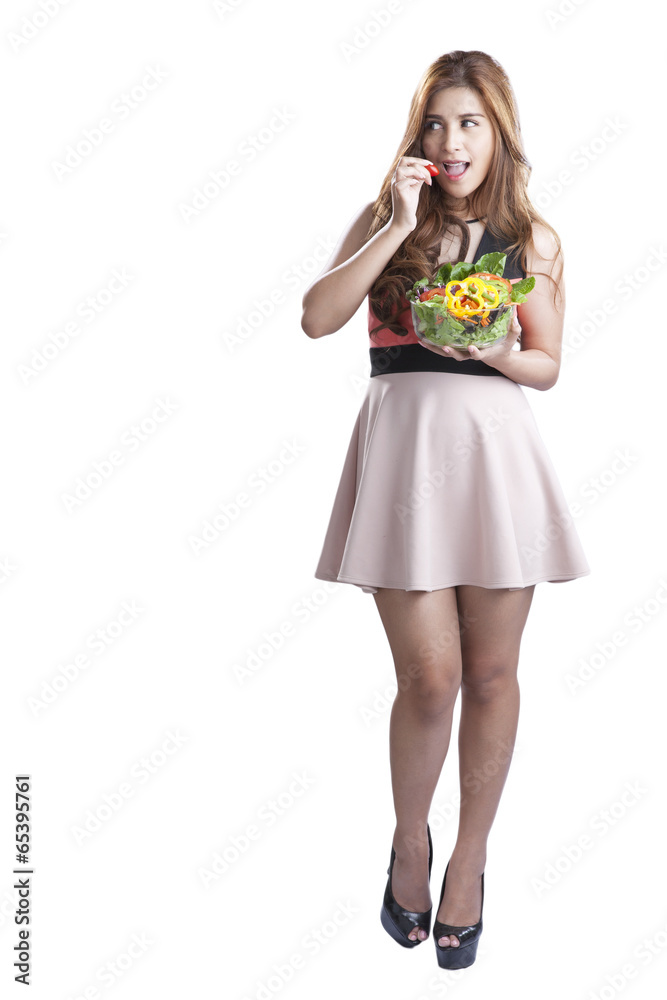 Young woman brunette present and eating salad Young woman brunette present and eating salad