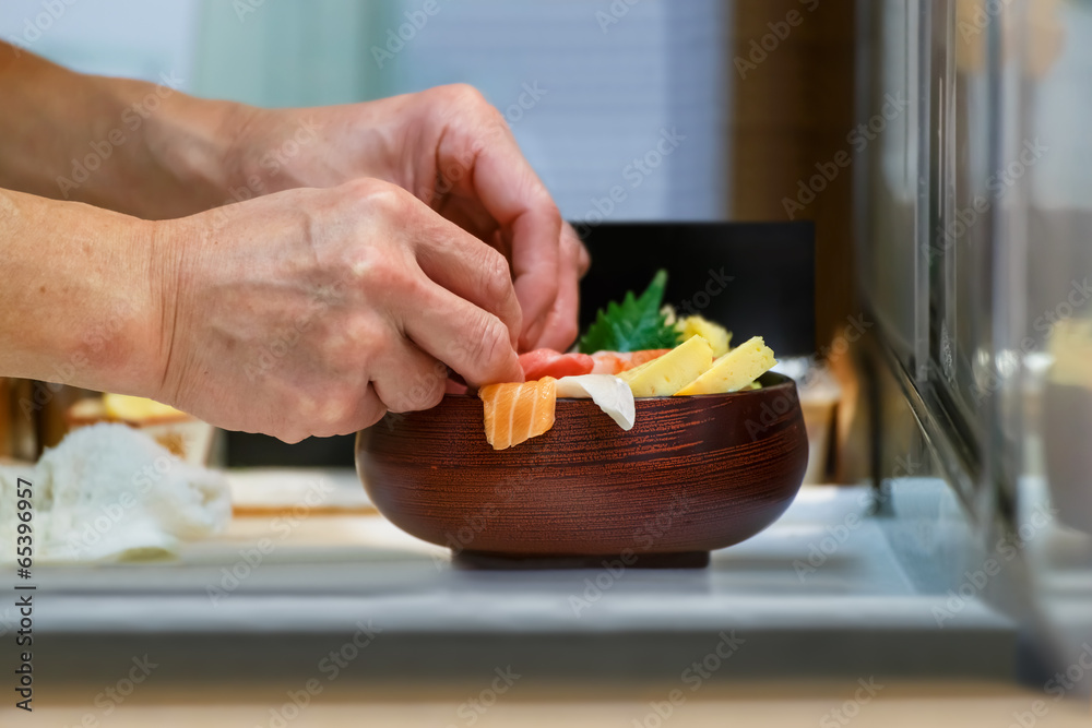 Fototapeta Hands of a Japanese Chef make a bowl of Sushi