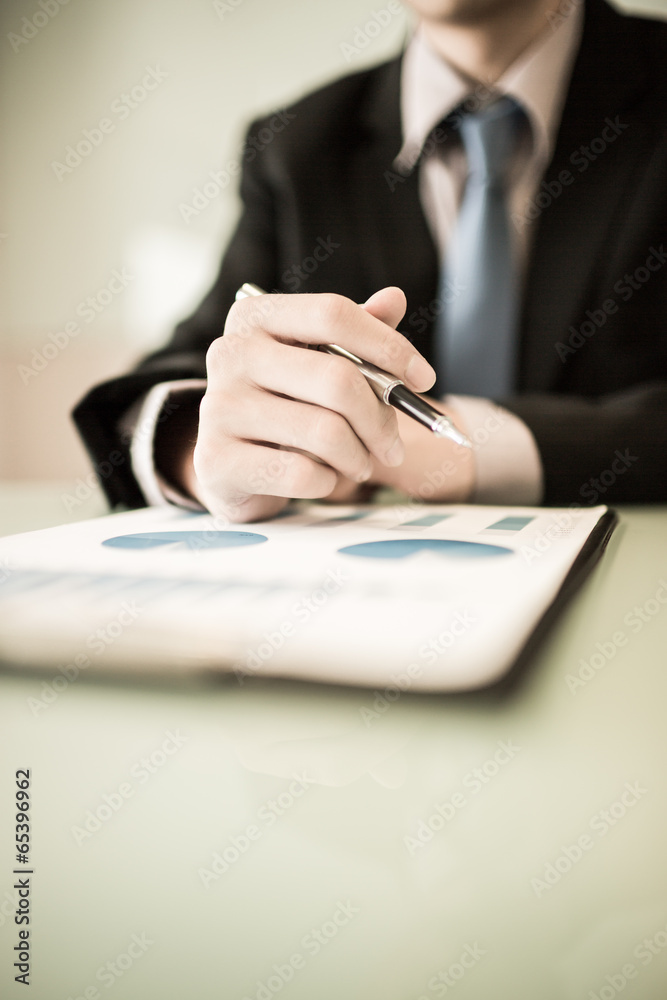 business report and man hand with pen business report and man hand with pen
