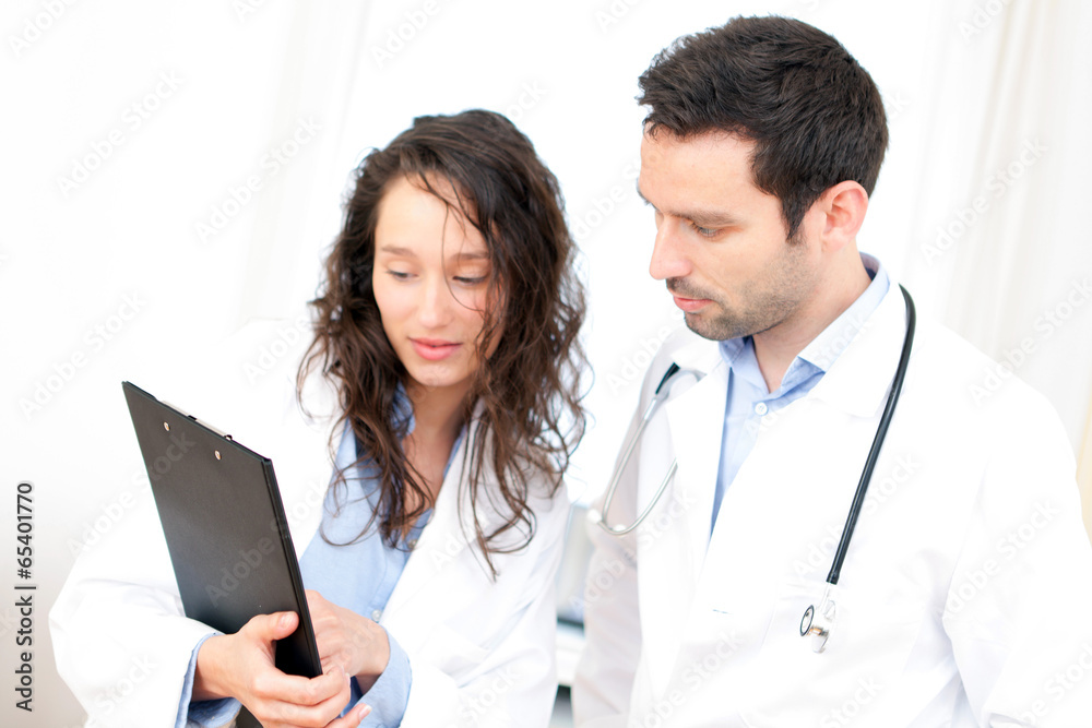 Young doctor and nurse analysing radiography Young doctor and nurse analysing radiography