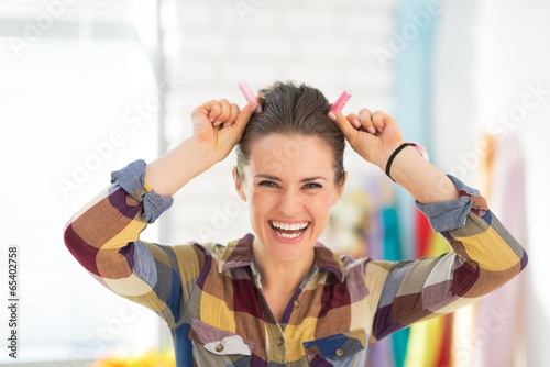 Portrait of happy seamstress making horns using thread photo