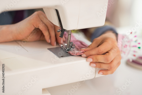 Closeup on seamstress sewing in studio