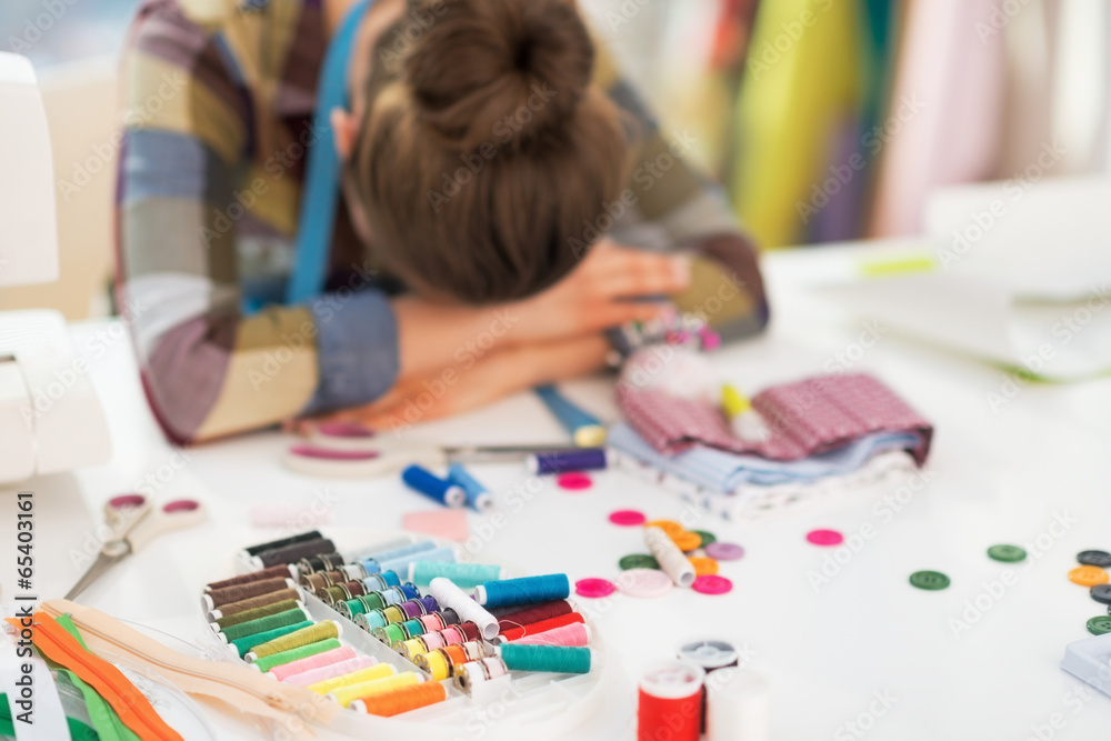 Tired seamstress sleeping in studio Tired seamstress sleeping in studio