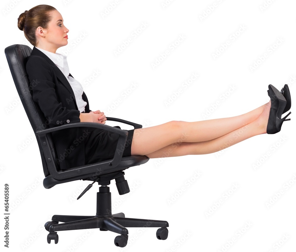 Businesswoman sitting on swivel chair with feet up Businesswoman sitting on swivel chair with feet up