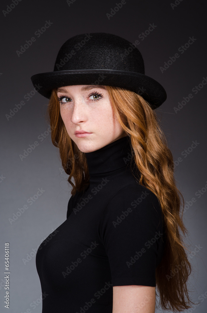 Redhead girl in hat against grey background Redhead girl in hat against grey background