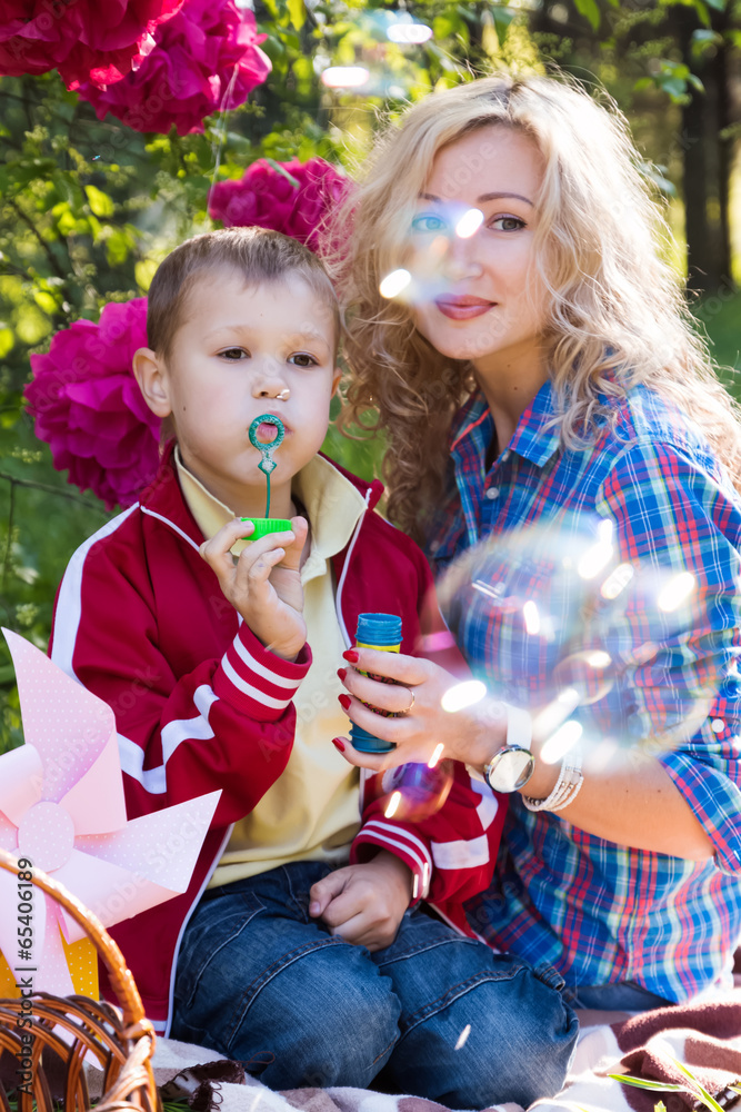 Mother and son blowing soap bubbles