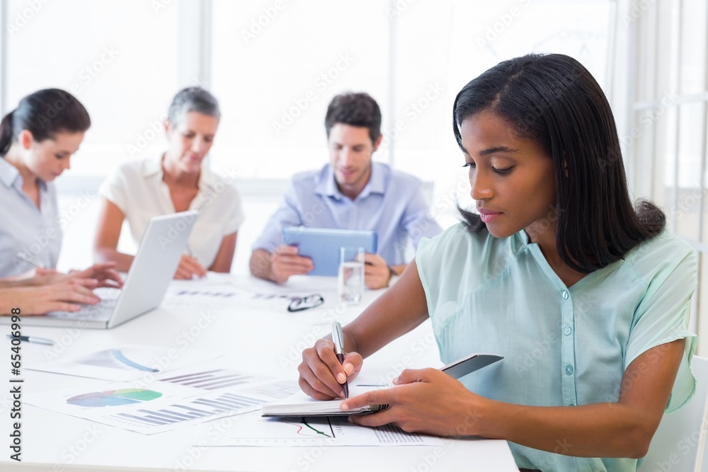 Casual businesswoman taking notes during meeting Casual businesswoman taking notes during meeting
