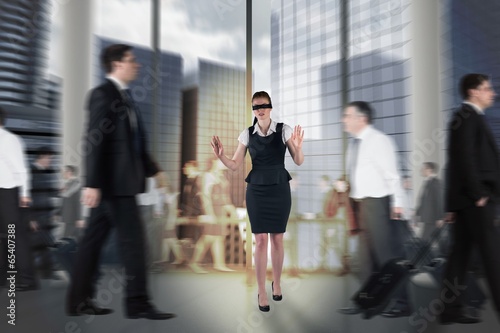 Composite image of redhead businesswoman in a blindfold