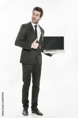 handsome man in a suit presenting a laptop with a blank screen