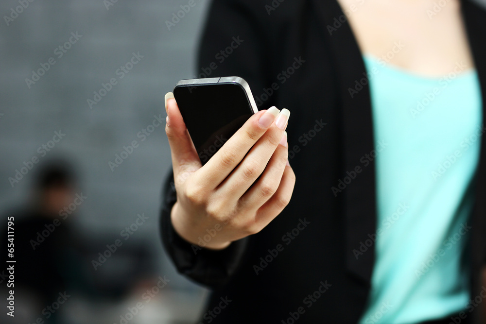 Closeup portrait of a female hands using smartphone in office