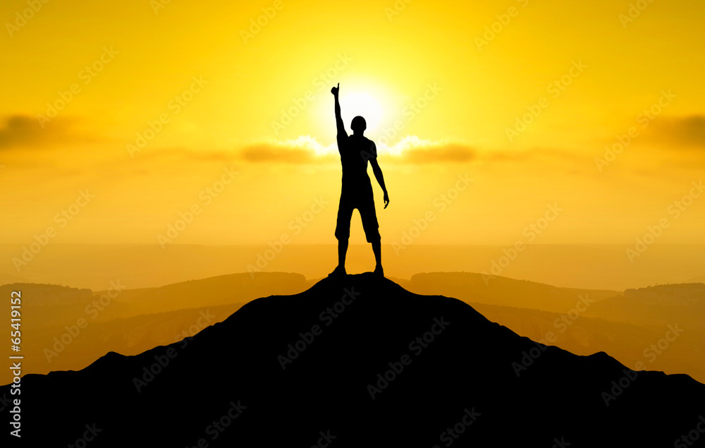 Champion on mountain peak during sunrise