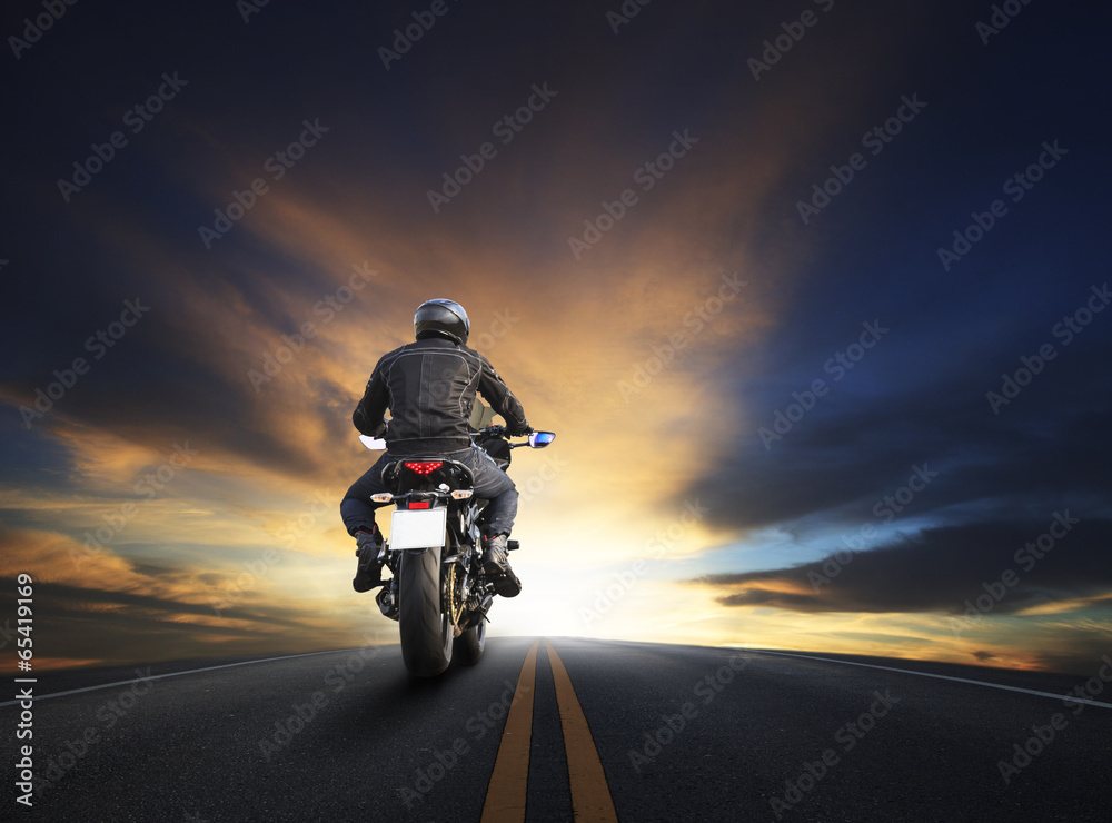 Naklejka premium młody mężczyzna jedzie duży motocykl na asfalcie wysoko przed