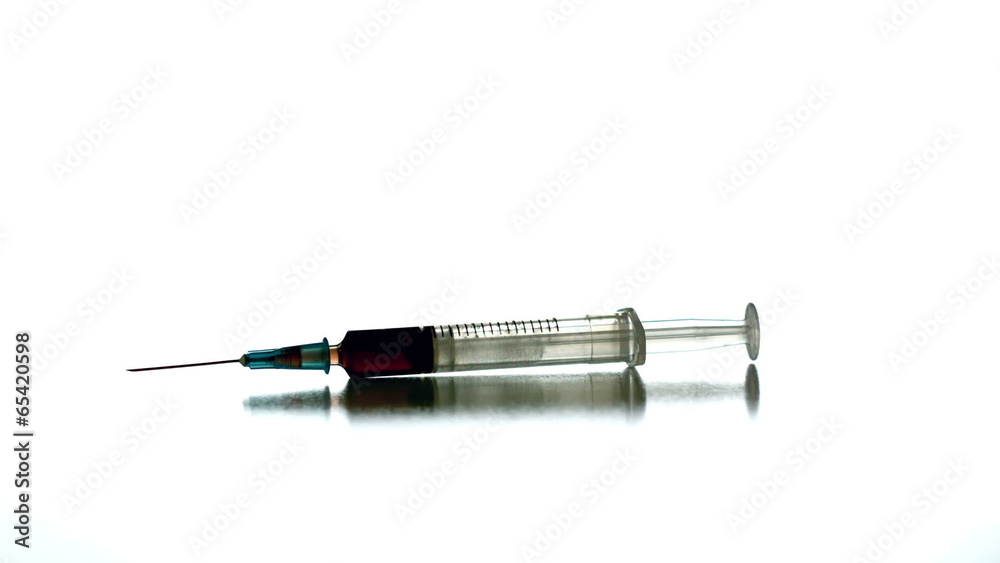Syringe spinning on white surface Syringe spinning on white surface