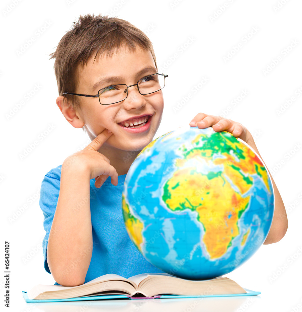 Little boy is holding globe while daydreaming Little boy is holding globe while daydreaming