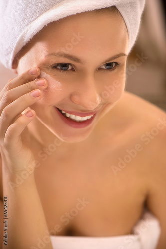 happy young woman touching face.