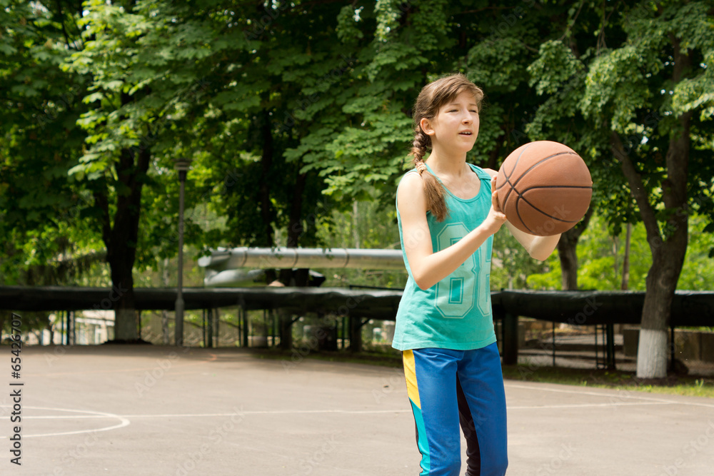 Beautiful teenage girl playing basketball