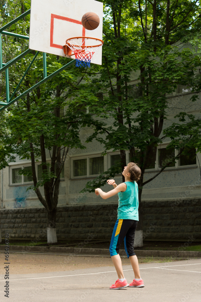 Young girl shooting a goal in basketball